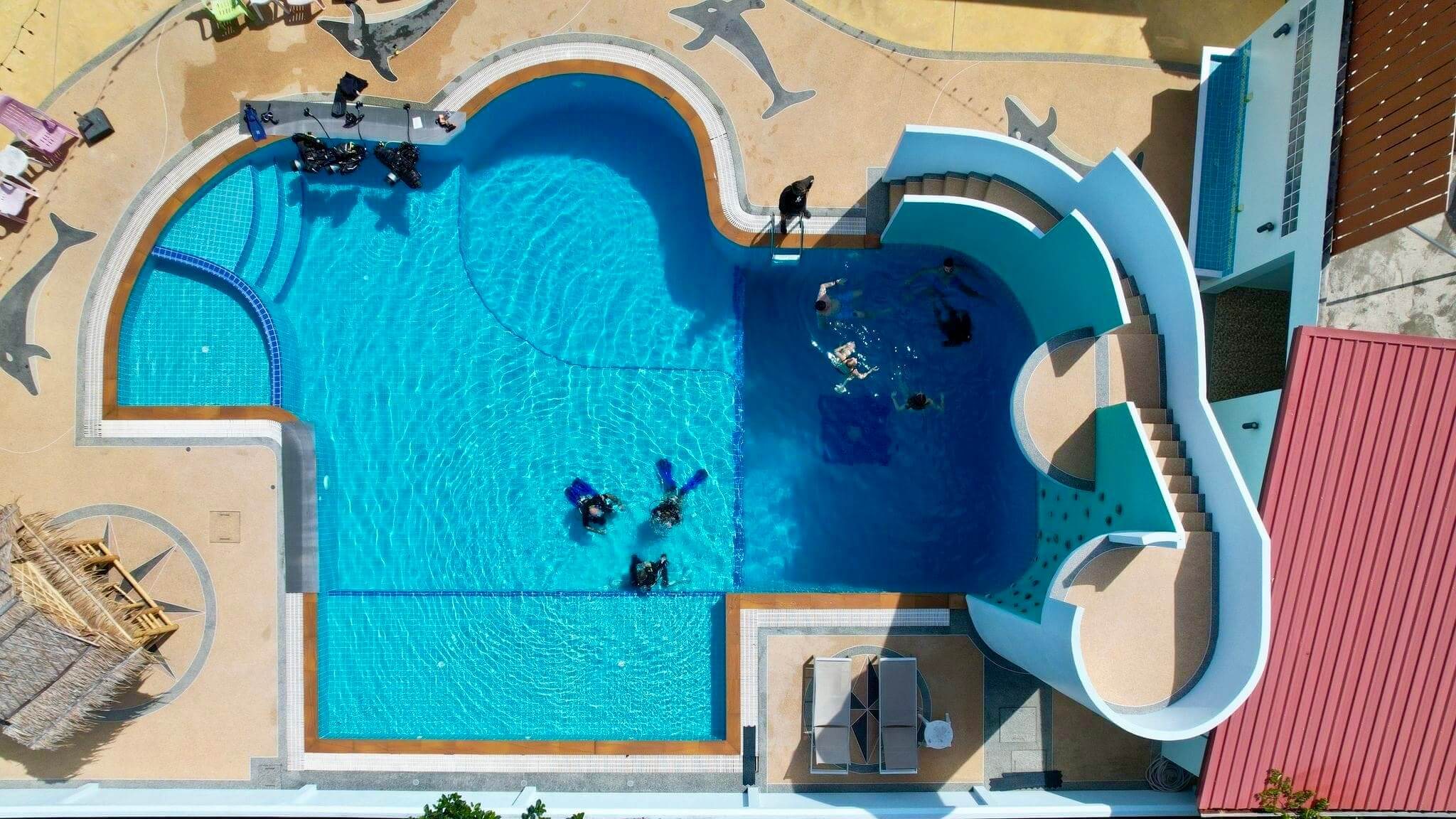 Aerial view of Aloha Diving's training pool in Phuket with groups of divers practising in the shallow and deep sections