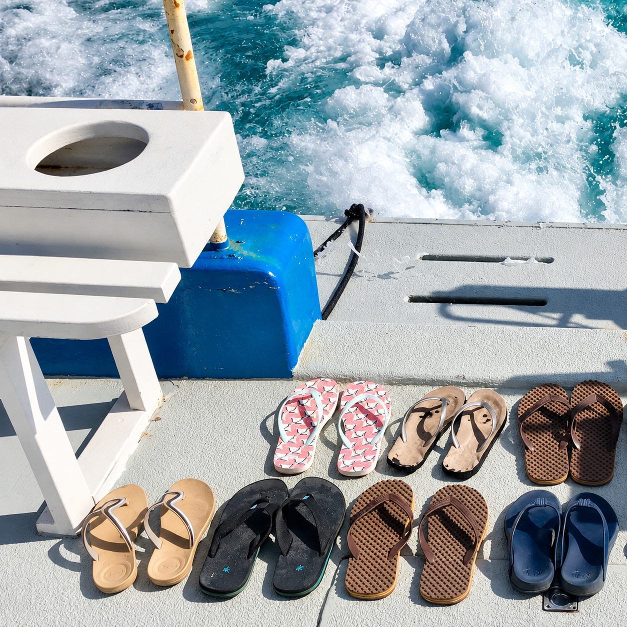 Guests’ flip-flops lined up on the swim deck, the wake foaming behind