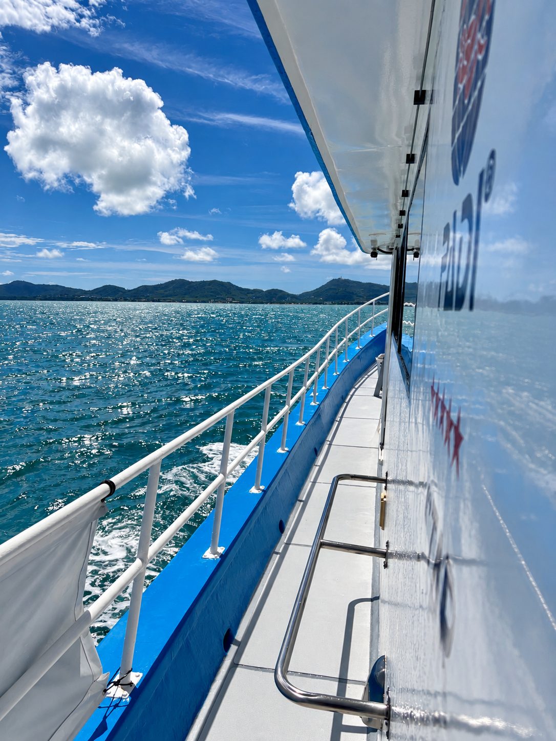 The port side deck along the cabin, the rail and the open sea