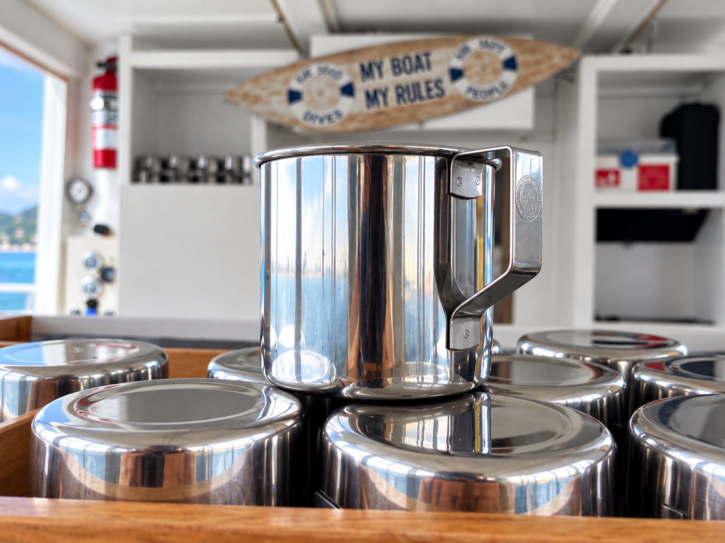 Stainless-steel cups in a wooden tray in the saloon
