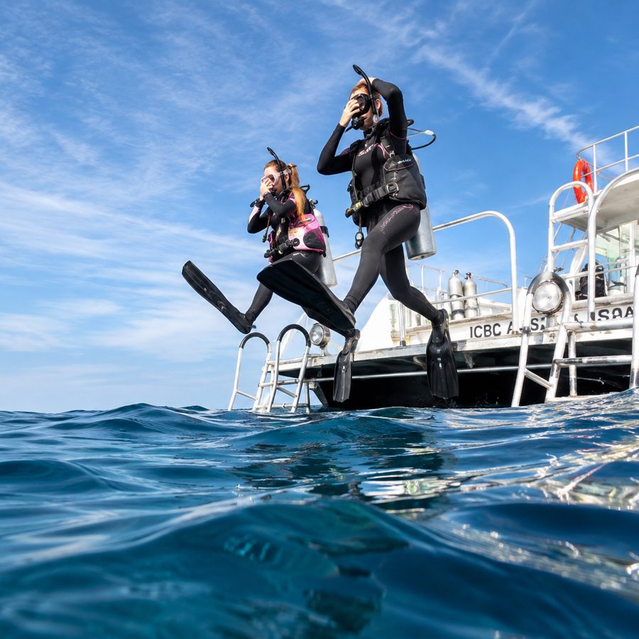 A diver stepping off the dive platform of a boat (PADI)