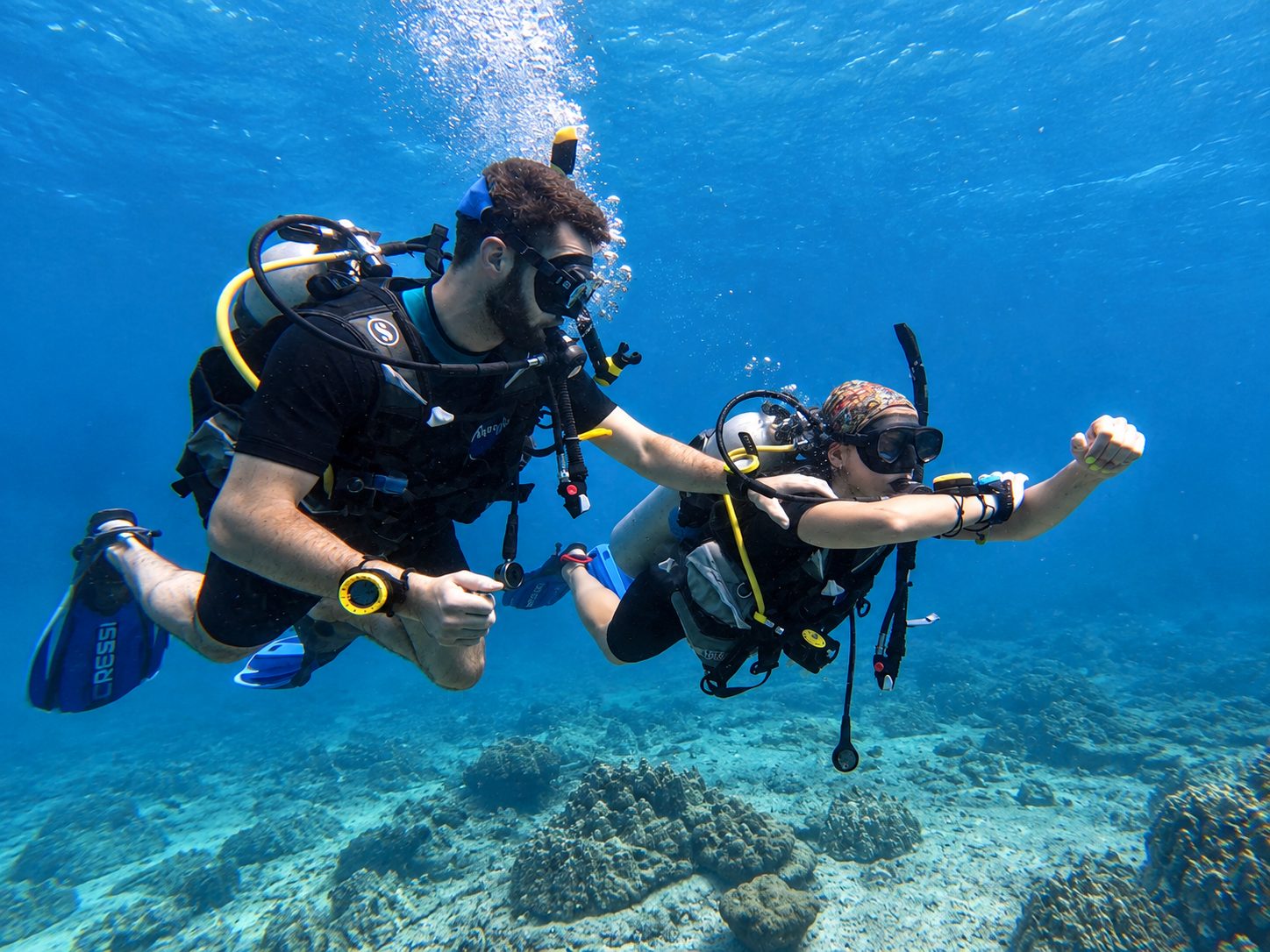 Two divers on a navigation exercise over the reef