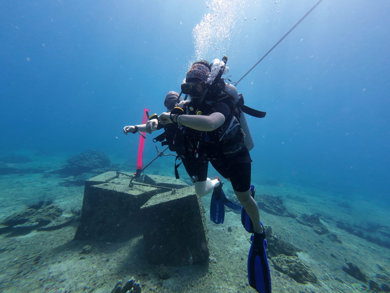 A diver holding the line at the concrete block in the training bay