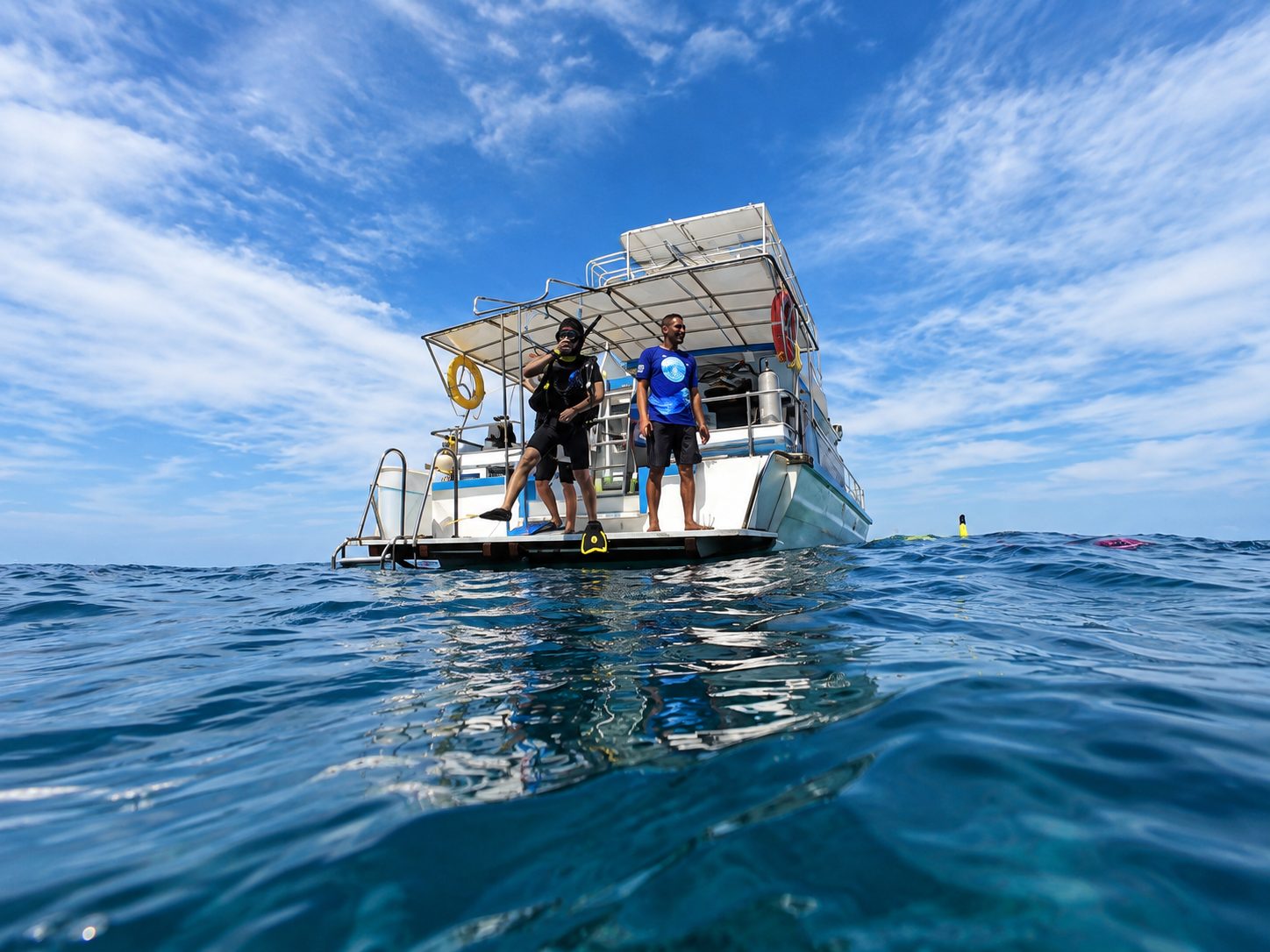 Guests on the dive platform of MV Matchanu, seen from the water