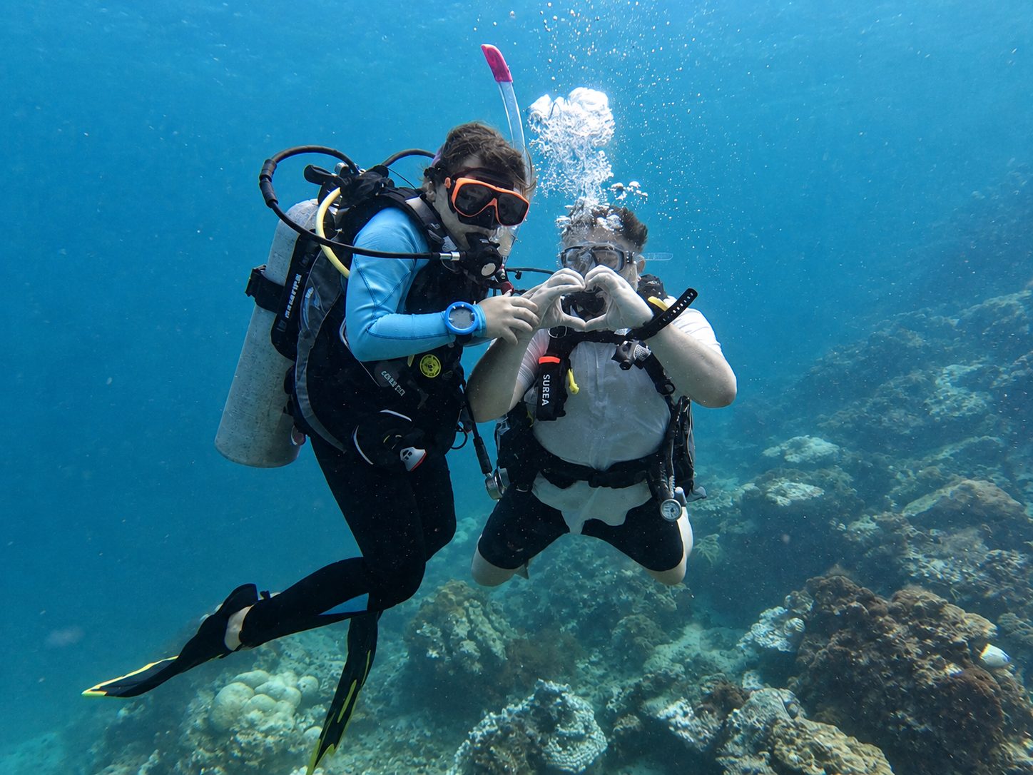 Two divers making a heart with their hands at Koh Mai Thon