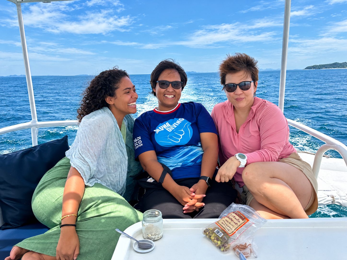 Three women sitting together on the sun deck, coffee and snacks on the table