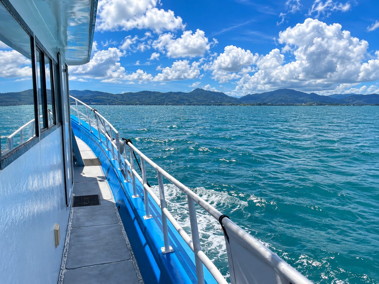 The bow of MV Matchanu cutting through calm blue water