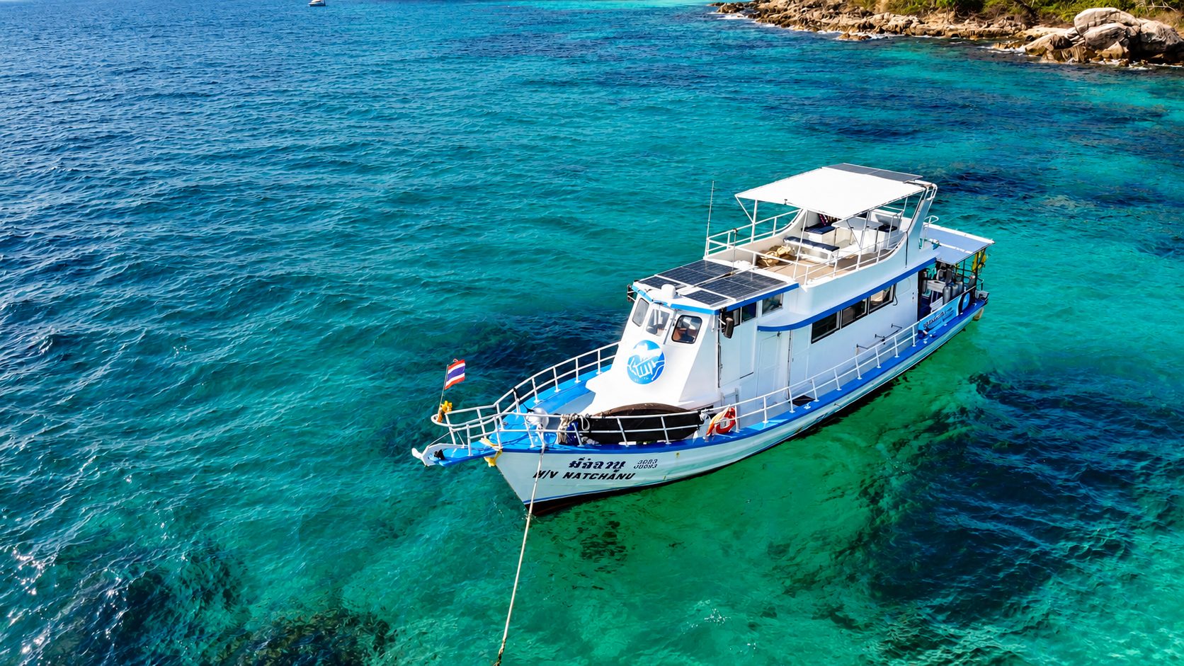 MV Matchanu seen from above, under way over turquoise water