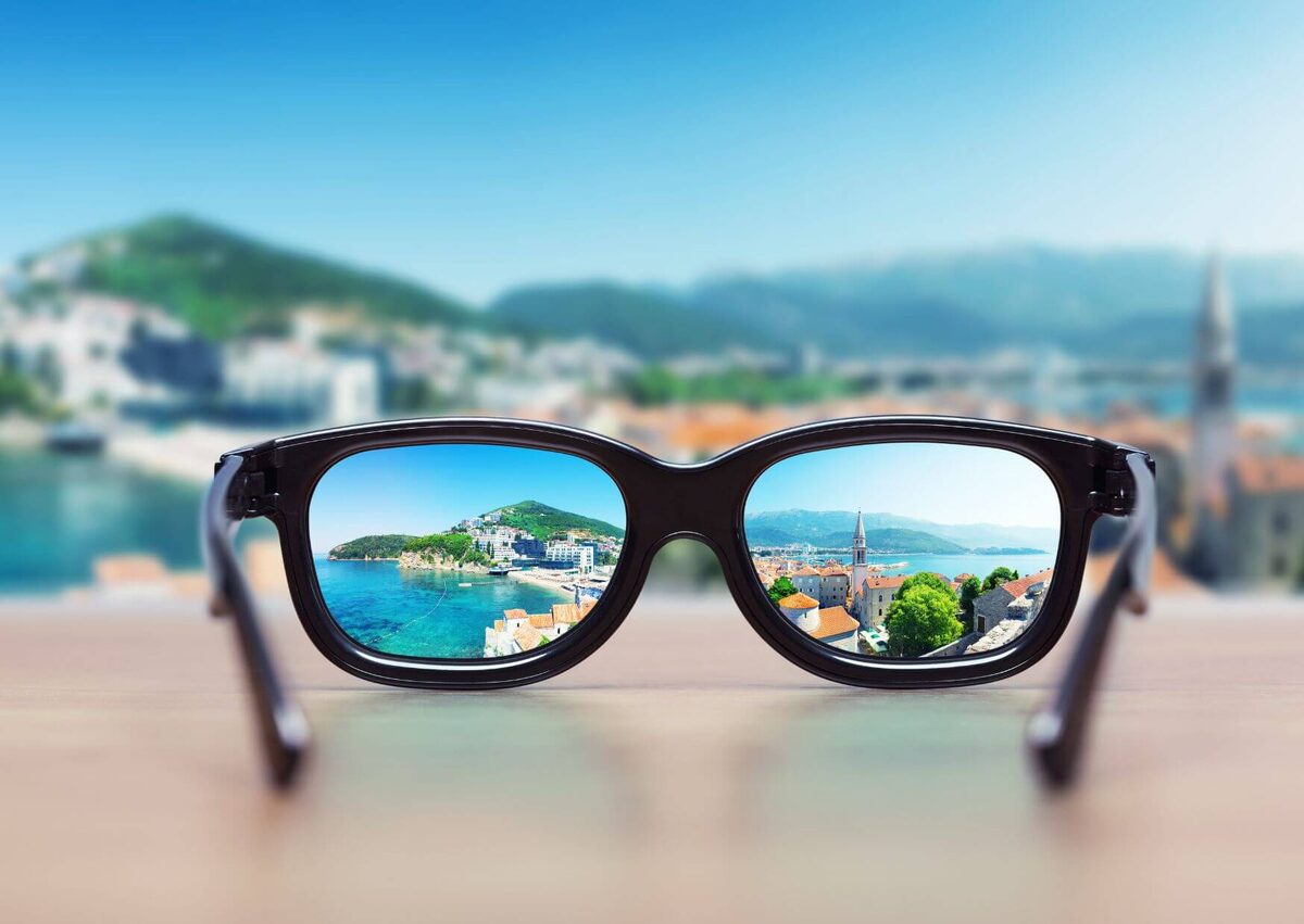 A pair of glasses held up in front of a scuba mask