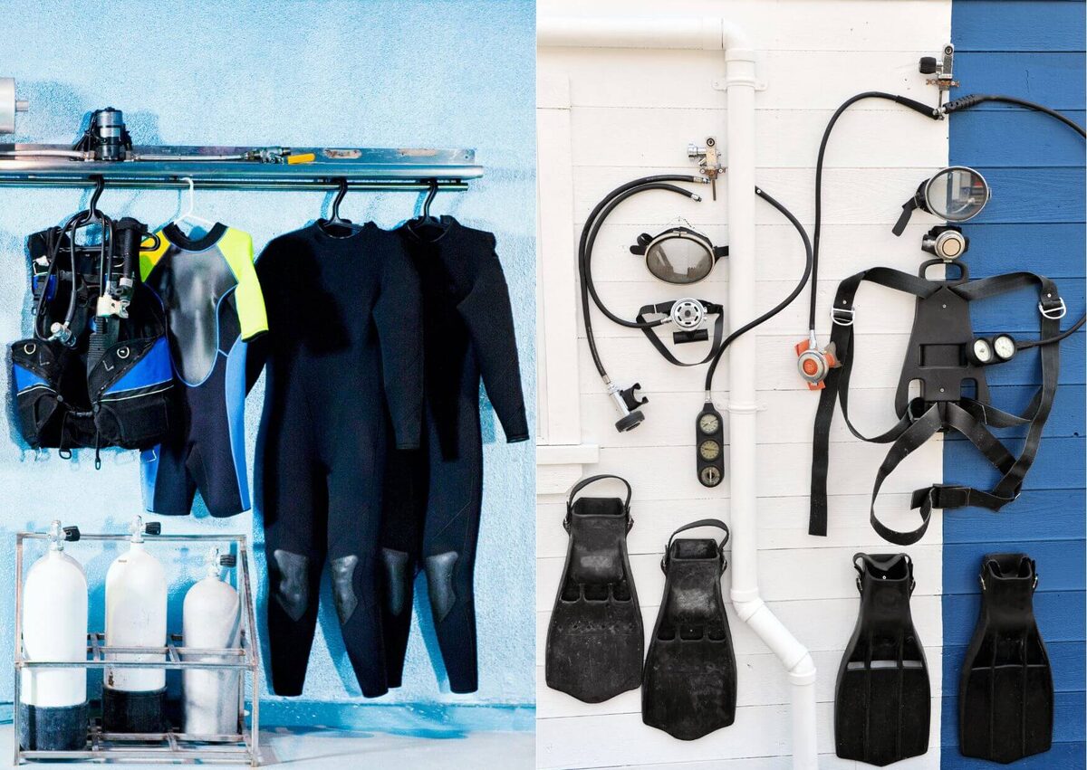 Wetsuits and BCDs hung to dry beside tanks, and dive gear laid out on a wall