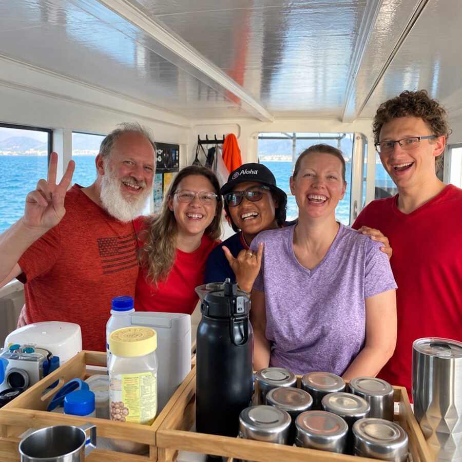 Bill Carmody and his family in the galley of MV Matchanu, all smiles and a peace sign