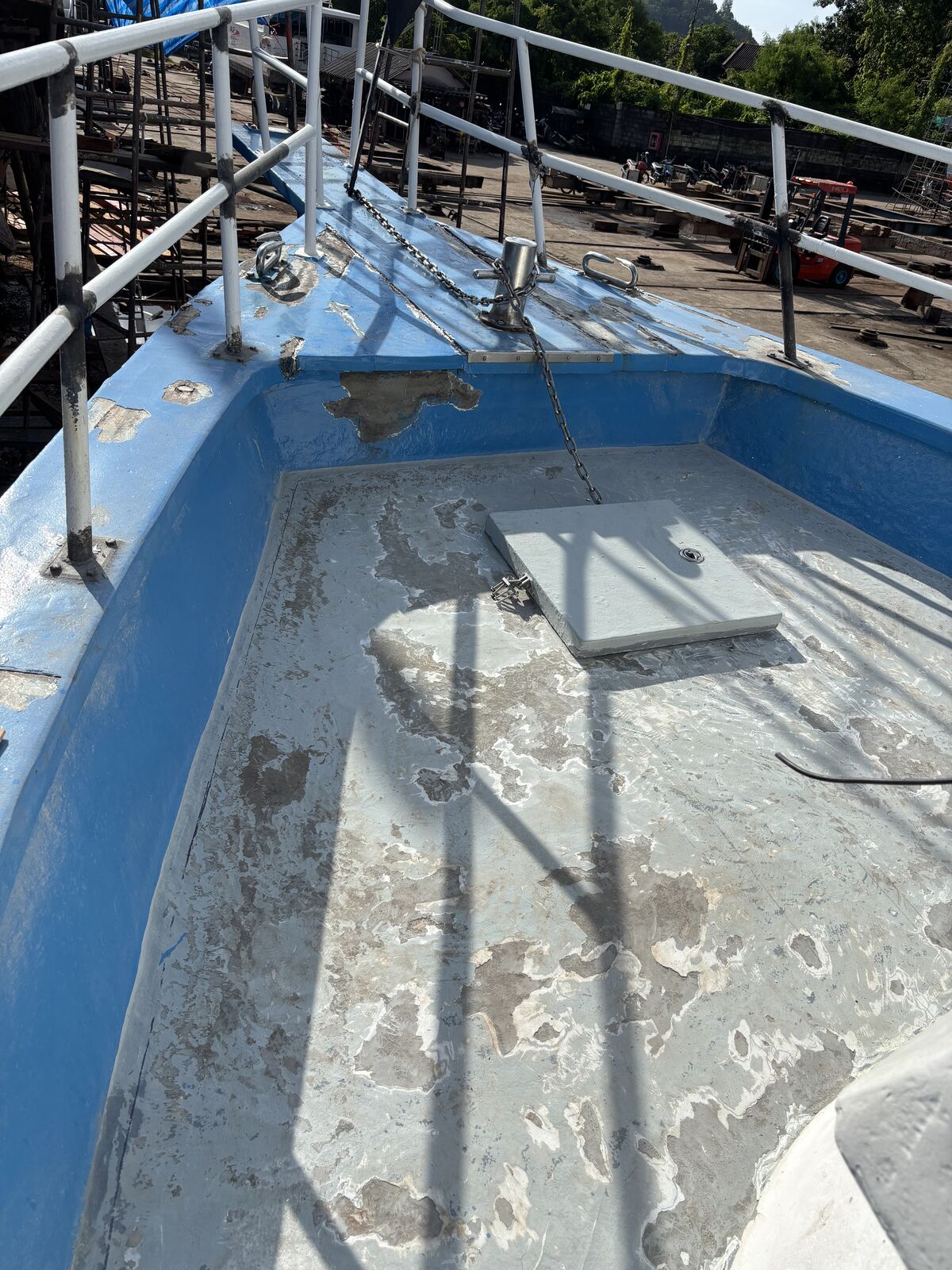 The bow deck sanded back to the primer, scaffolding poles along the rail