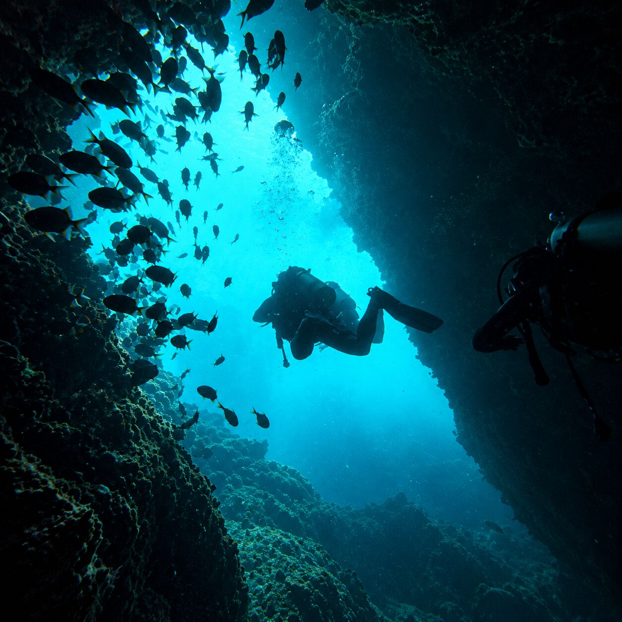 Small cave exit with divers at Koh Doc Mai