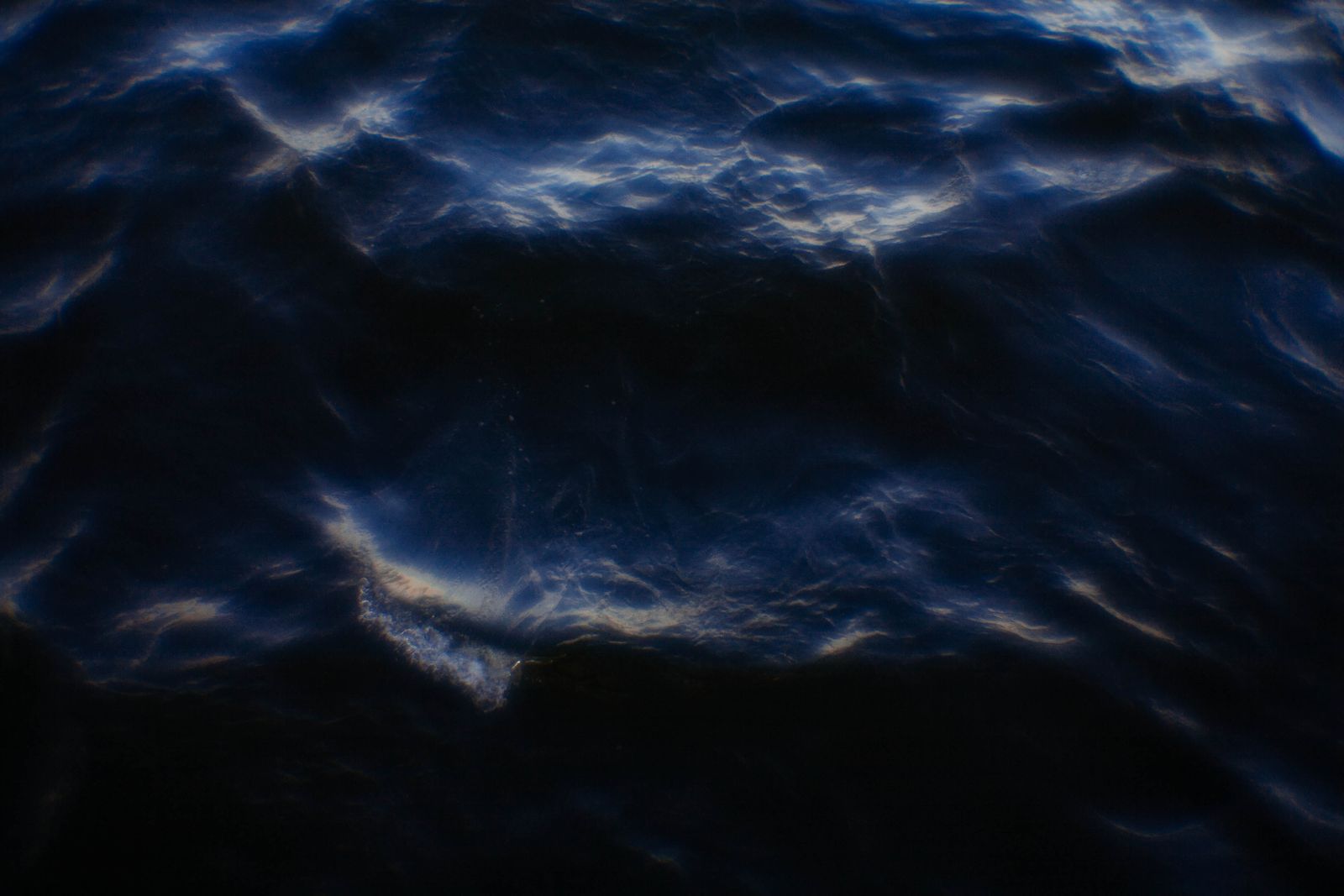 A diver descending into deep blue water