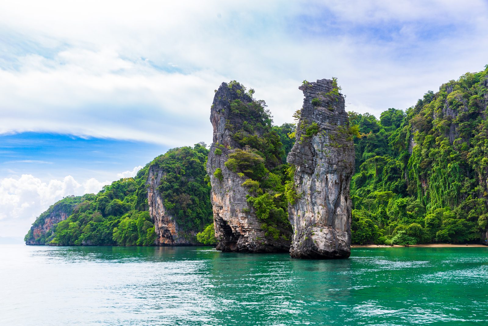 Limestone islands standing in the bay under a cloudy sky